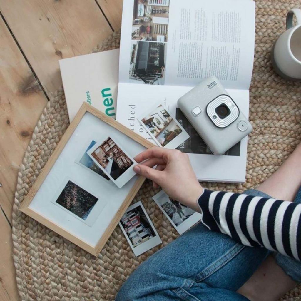 Flicka är kreativ med sina tryckta instaxbilder från sin instax minikamera