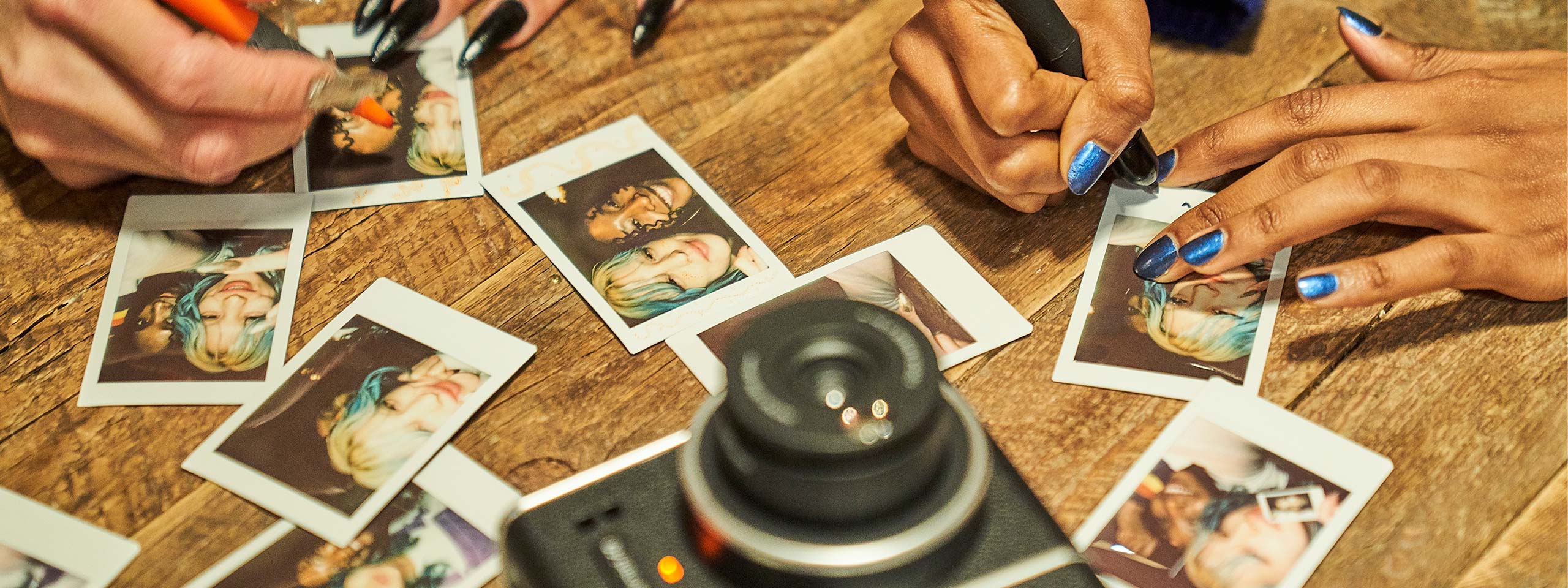 Instax wide kamera i selfieläge på bordet med instax filmfot